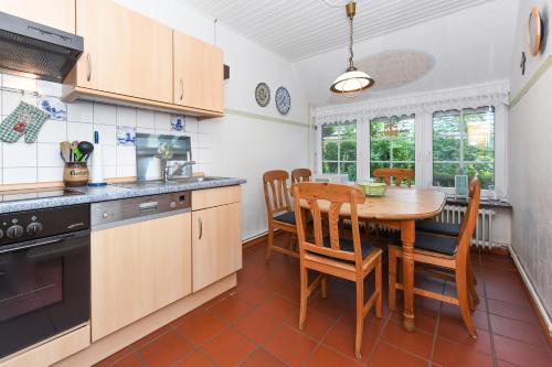 a kitchen with a wooden table and a dining room at Ferienhaus Dohlennest in Carolinensiel