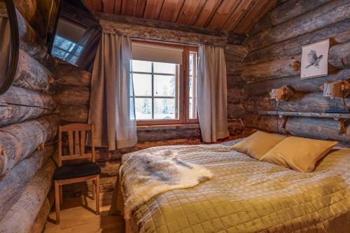 a bedroom with a bed in a log cabin at Kuusirinne 2A - a log cabin near the slopes of Ruka in Ruka