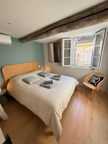 une chambre avec un grand lit blanc avec une fenêtre dans l'établissement Maison climatisée avec parking et rooftop, à Avignon