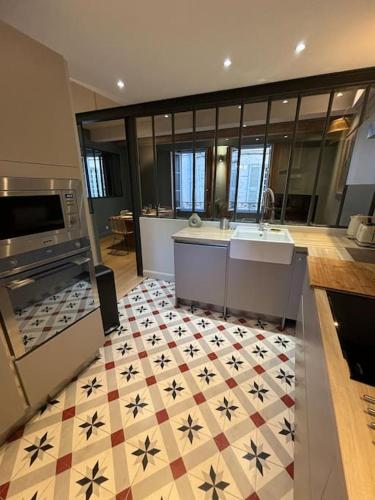 Il comprend une grande cuisine dotée de carrelage et d'un comptoir. dans l'établissement Maison climatisée avec parking et rooftop, à Avignon