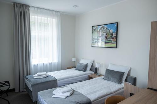 a hotel room with two beds and a window at Dwór Skrzynki in Skrzynki