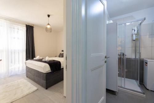 a bedroom with a bed and a glass shower at Apartman Zelic Split in Split