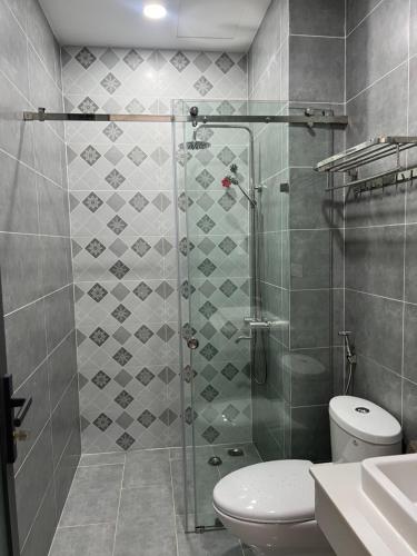 uma casa de banho com um chuveiro, um WC e um lavatório. em KHÁCH SẠN HÀ PHƯƠNG em Tánh Linh