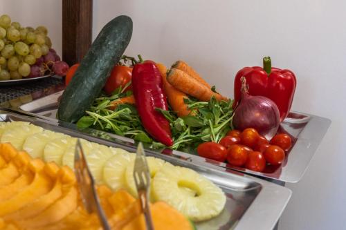 two trays of fruits and vegetables on a table at B&B Plitvice Queen in Plitvička Jezera