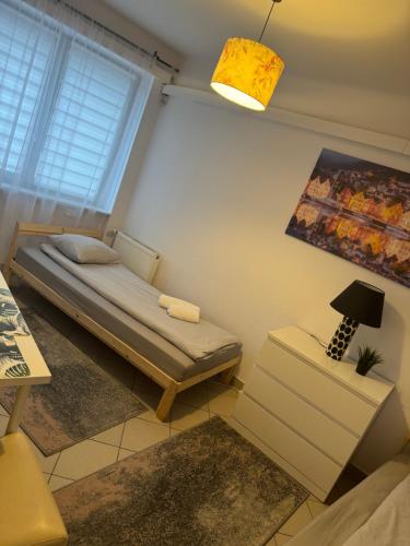 a small room with a bed and a lamp at ESA Home in Warsaw