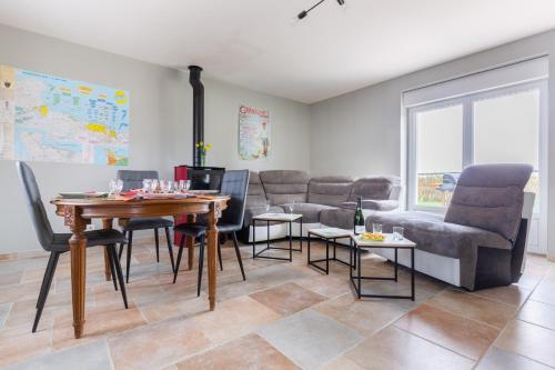 un salon avec une table et des chaises dans l'établissement La Pêcherie d'Utah, à Audouville-la-Hubert