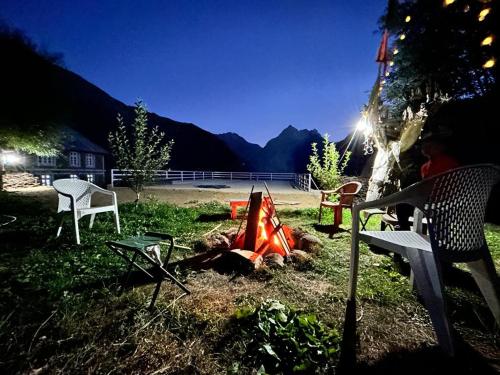 a fire in the grass with chairs and a bench at Lahaul Home Stay Sumnam in Tāndi