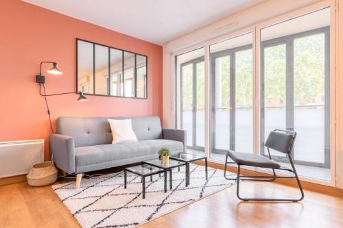 a living room with a couch and a table at Euratechnologies - Bright apartment with parking in Lille