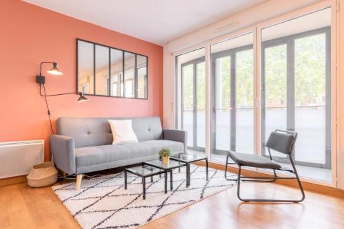 un salon avec un canapé et une table dans l'établissement Euratechnologies - Bright apartment with parking, à Lille