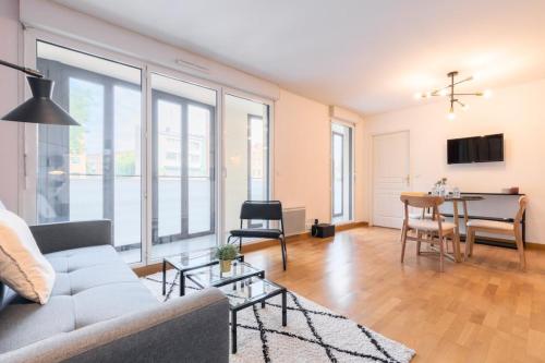 ein Wohnzimmer mit einem Sofa und einem Tisch in der Unterkunft Euratechnologies - Bright apartment with parking in Lille