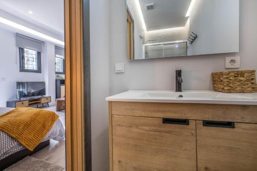 W łazience znajduje się umywalka i lustro. w obiekcie Garesc Lofts w Kordobie