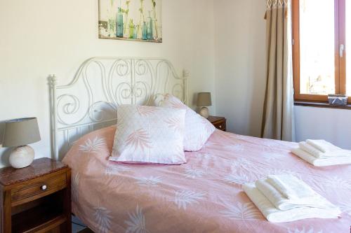Laprade的住宿－Gite Charbonnaud，一张带粉红色床单的白色床和两条毛巾