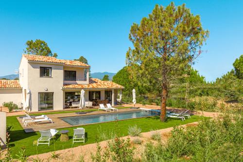 une maison avec une piscine dans la cour dans l'établissement Calarossa Bay Resort, à Porto-Vecchio
