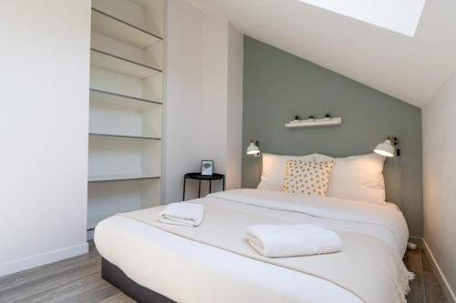 - une chambre avec un grand lit blanc et des étagères dans l'établissement Lille Hypercentre / Gares - Beautiful duplex!, à Lille