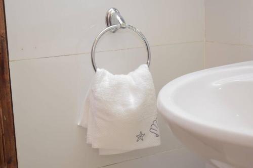 eine Rolle Toilettenpapier auf einem Handtuchhalter neben einem Waschbecken in der Unterkunft Marvel Homes in Meru
