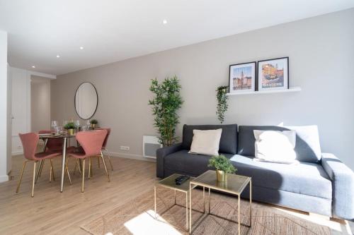 een woonkamer met een blauwe bank en een tafel bij Hypercentre -Apartment in pedestrian zone in Lille