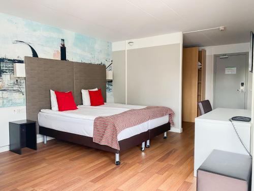 a bedroom with a bed with red pillows at Good Morning+ Hägersten in Stockholm