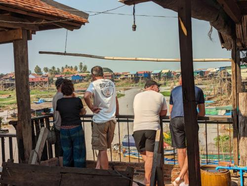 a group of people standing on a fence at ST 63 Home Stay & Tour Kampong Khleang in Kâmpóng Khleăng