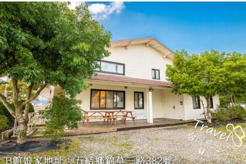 una casa con una mesa de picnic delante de ella en 建築師湧泉泡湯會館, en Dongshan