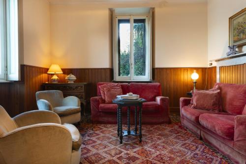 a living room with red furniture and a table at Villa Guardini by Wonderful Italy in Varenna