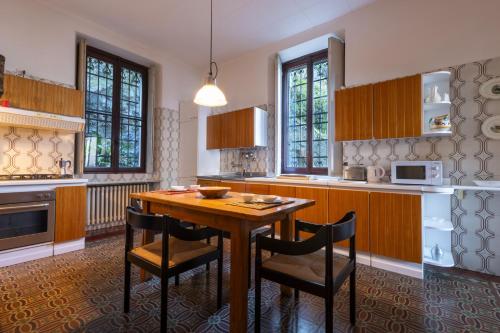 a kitchen with a wooden table and chairs at Villa Guardini by Wonderful Italy in Varenna