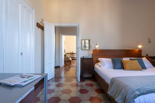 a bedroom with two beds and a table in it at Villa Guardini by Wonderful Italy in Varenna