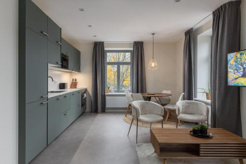 a kitchen and dining room with a table and chairs at Ķīpsala apartments with free parking in Riga