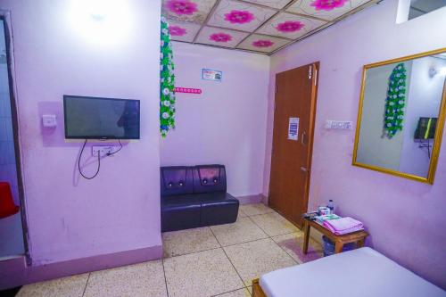 - un salon avec un canapé et une télévision dans l'établissement Hotel Victoria Inn (Nazimuddin Road), à Dhaka