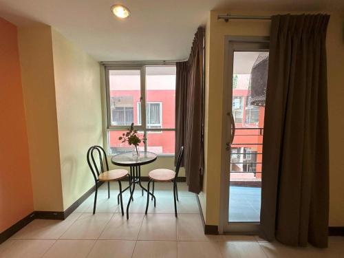 a dining room with a table and chairs and a window at Aryan Suites Hotel in Bangkok