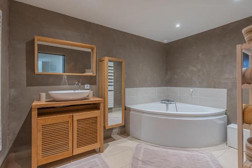 une salle de bain avec une baignoire et un lavabo et une baignoire dans l'établissement Nonna Maria l Maison, 6 pers, à Chapareillan