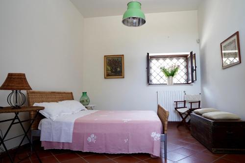 una camera da letto con un letto, una finestra e una sedia di Tenuta il Carrubo - Dimora storica a Bisceglie
