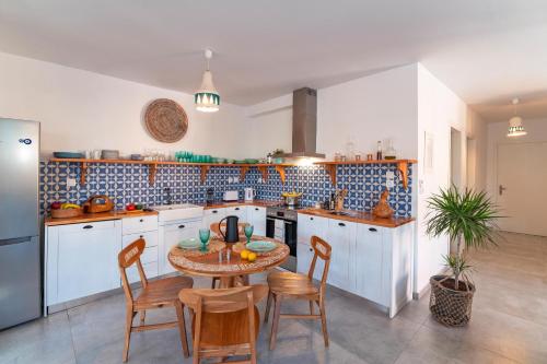 a kitchen with a table and chairs in it at Onar Villa Kolympia in Kolimbia