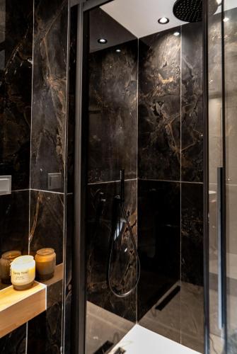 a bathroom with a shower with black tiles at Sea & the City in Thessaloniki