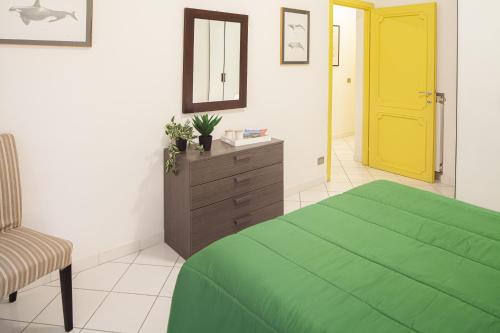 een slaapkamer met een groen bed en een gele deur bij Sirene 4 in Levanto