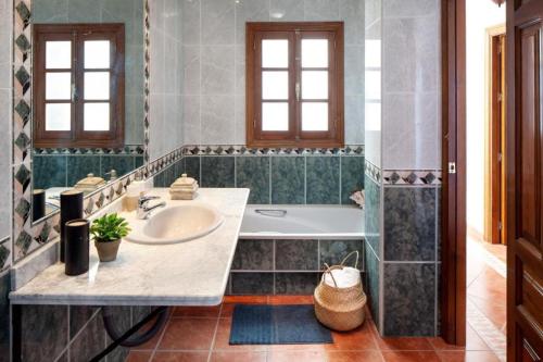 a bathroom with a sink and a tub at TESS Casa La Alcazaba de Serrato in Serrato