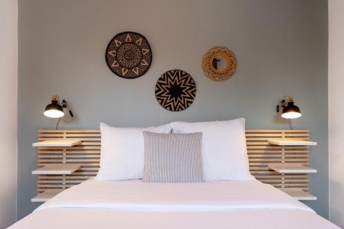sypialnia z białym łóżkiem z 3 płytami na ścianie w obiekcie Grand' Place of Lille - Superb designer apartment w Lille