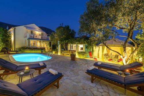 une arrière-cour avec une piscine et une maison dans l'établissement Villa Piano, à Mlini