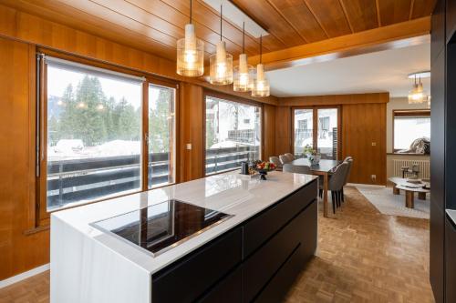 a kitchen with a white counter top and a large window at Chalet Alberti Davos Platz in Davos