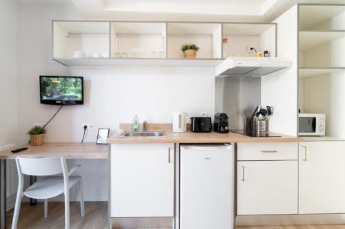 une cuisine avec des armoires blanches et un comptoir en bois dans l'établissement Lille Hypercentre/Railway stations -Nice studio, à Lille