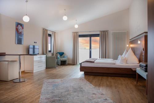 um quarto com uma cama grande e uma janela grande em Hotel APARTmenthouse em Rülzheim