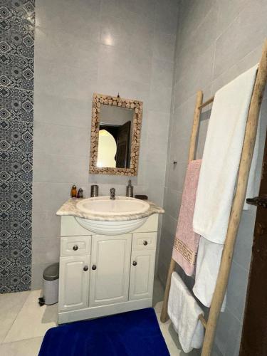 a bathroom with a white sink and a mirror at Oasis Merasi Marrakech in Marrakech