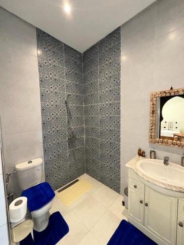 a bathroom with a toilet and a sink and a mirror at Oasis Merasi Marrakech in Marrakech