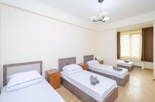 a room with three beds and a ceiling at Areva Hostel & Apartment in Yerevan