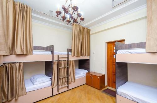 a room with three bunk beds and a chandelier at Areva Hostel & Apartment in Yerevan