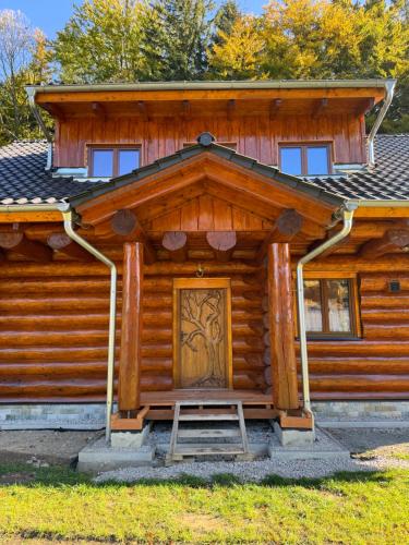 Cabaña de madera con puerta en la parte delantera en Srub Čeladná, en Čeladná