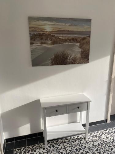 a white desk in a room with a painting on the wall at Ferienhaus Paula in Marlow
