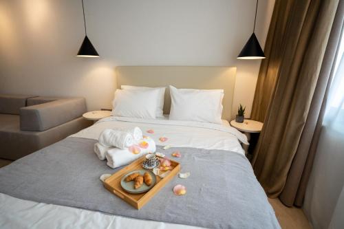 a hotel room with a tray of food on a bed at Sea & the City in Thessaloniki