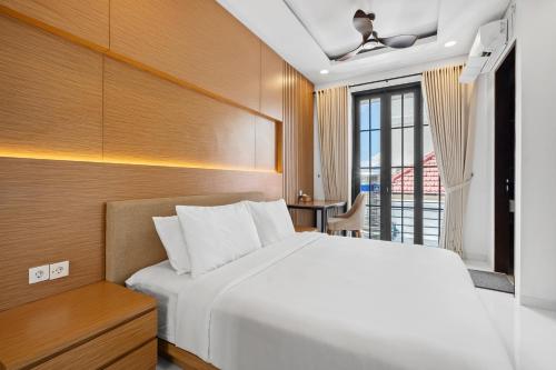a bedroom with a white bed and a balcony at Asasta Villa by Betterplace in Tabanan