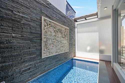 a wall with a painting on it next to a swimming pool at Asasta Villa by Betterplace in Tabanan