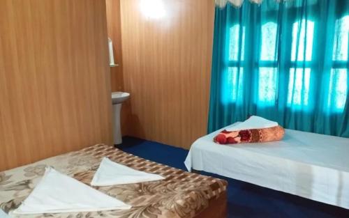 a hotel room with two beds and a window at The Leo Homestay Cottage by StayApart , Buxa in Jayanti